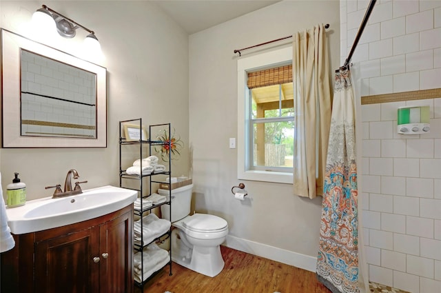 bathroom featuring wood-type flooring, toilet, vanity, and a shower with curtain