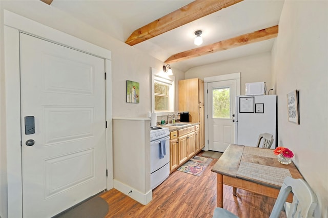 kitchen with white appliances, wood-type flooring, light brown cabinets, sink, and beam ceiling