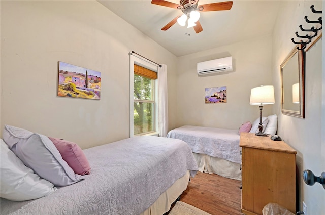 bedroom featuring ceiling fan, wood-type flooring, and a wall mounted air conditioner