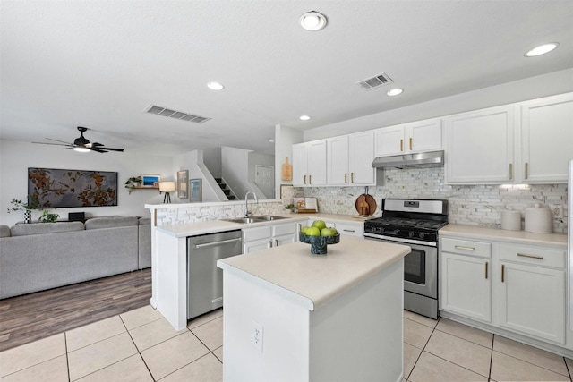 kitchen featuring ceiling fan, white cabinets, light tile patterned floors, sink, and stainless steel appliances