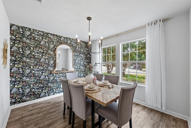 dining space with plenty of natural light, an inviting chandelier, and wood-type flooring