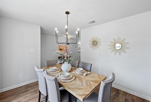 dining space with dark hardwood / wood-style flooring and a chandelier