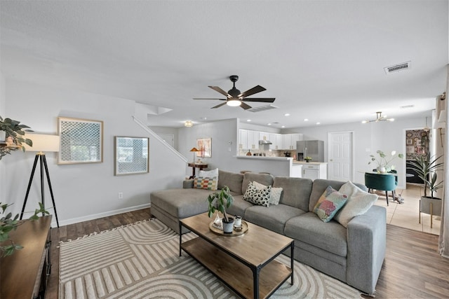 living room with ceiling fan and light hardwood / wood-style flooring