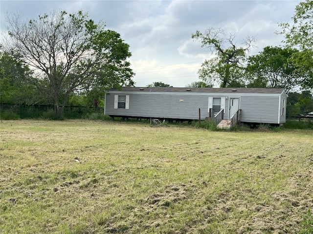 rear view of house with a yard and entry steps