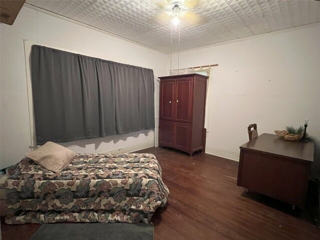 bedroom with dark hardwood / wood-style flooring and ceiling fan