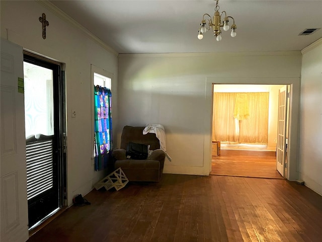 unfurnished room with a chandelier, crown molding, and wood-type flooring