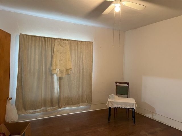 unfurnished room featuring dark wood-type flooring and ceiling fan