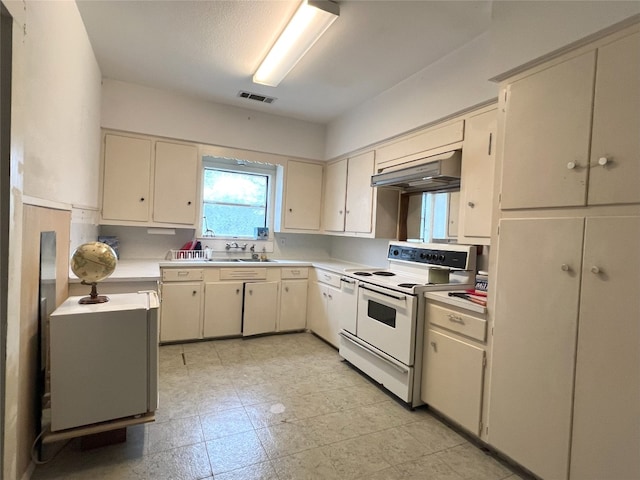 kitchen featuring under cabinet range hood, light countertops, visible vents, white electric range oven, and cream cabinets