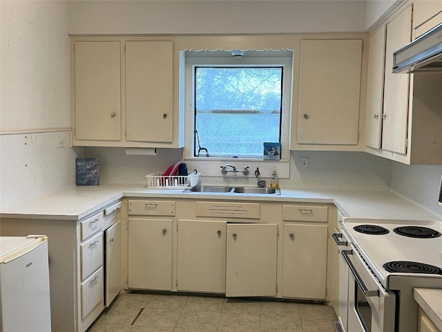 kitchen with white electric range oven, a sink, light countertops, cream cabinetry, and under cabinet range hood