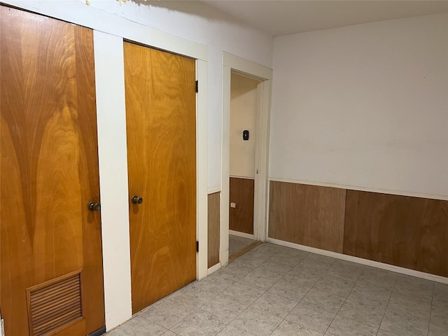 empty room featuring a wainscoted wall