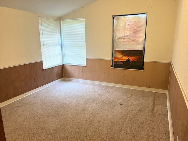 carpeted spare room featuring vaulted ceiling