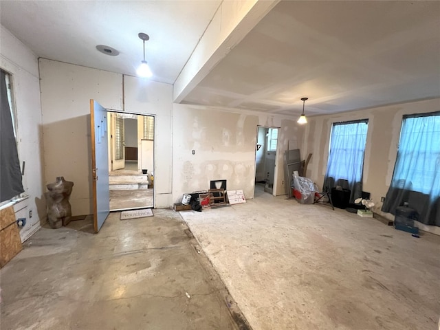 interior space with unfinished concrete floors and a healthy amount of sunlight