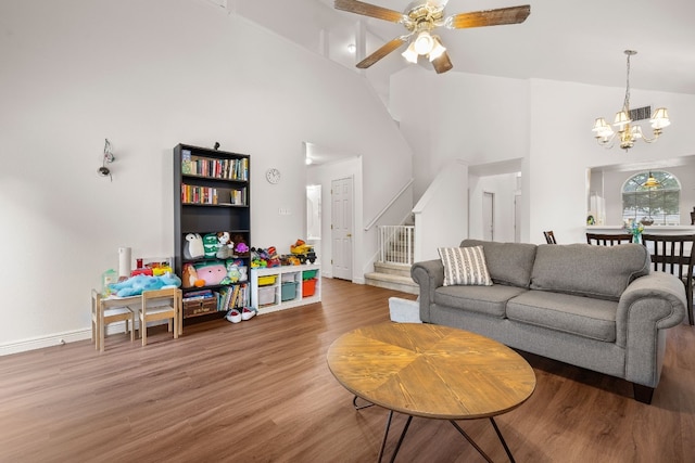 living room featuring hardwood / wood-style floors, ceiling fan with notable chandelier, and high vaulted ceiling