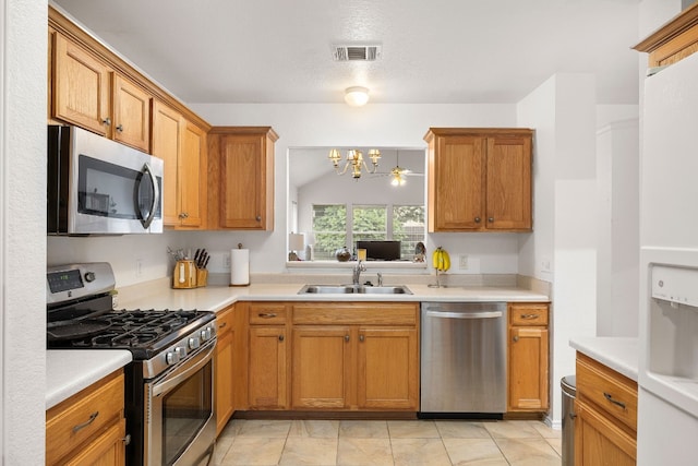 kitchen with ceiling fan with notable chandelier, light tile patterned flooring, sink, and stainless steel appliances