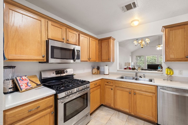 kitchen featuring ceiling fan with notable chandelier, sink, vaulted ceiling, light tile patterned flooring, and stainless steel appliances