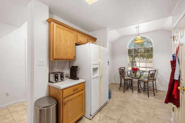 kitchen with decorative light fixtures, white refrigerator with ice dispenser, and vaulted ceiling