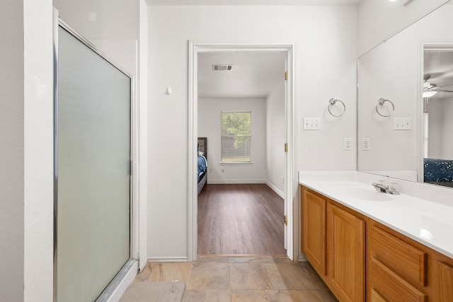 bathroom with vanity, ceiling fan, and a shower with shower door