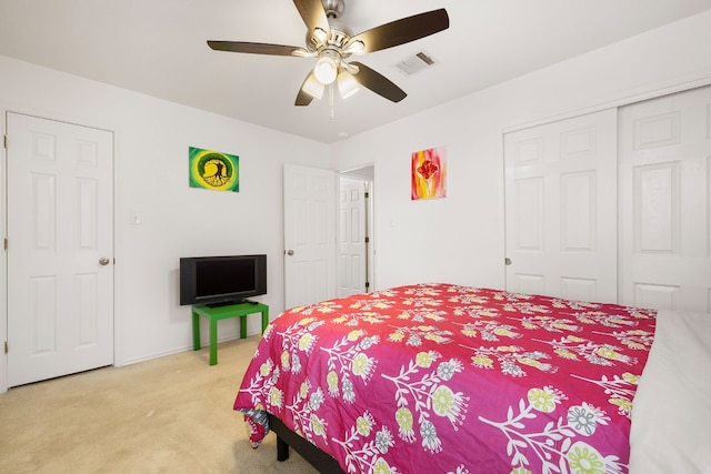 bedroom featuring ceiling fan, light carpet, and a closet