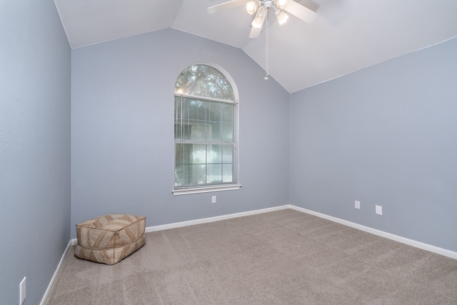 spare room with ceiling fan, a healthy amount of sunlight, light colored carpet, and lofted ceiling