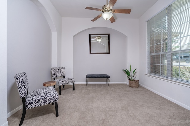 sitting room with ceiling fan and light carpet