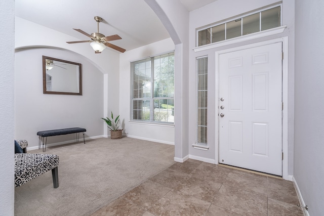 foyer entrance featuring ceiling fan and light colored carpet