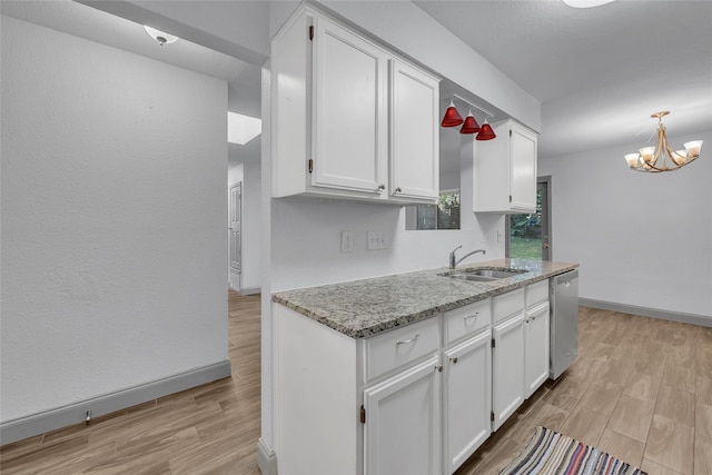 kitchen with light hardwood / wood-style floors, light stone countertops, stainless steel dishwasher, white cabinets, and sink