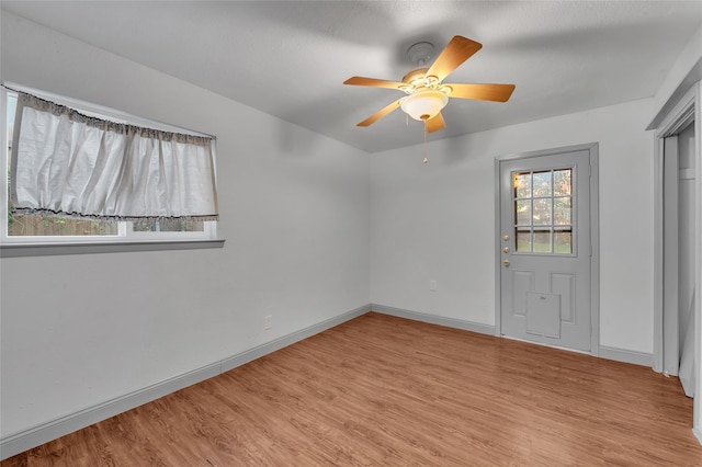 unfurnished room featuring ceiling fan, light hardwood / wood-style flooring, and a healthy amount of sunlight