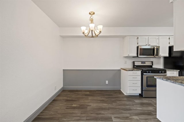 3411 Thomas Kincheon St, Austin, TX 78745 - kitchen featuring appliances with stainless steel finishes, a chandelier, white cabinetry, dark wood-style flooring, and pendant lighting