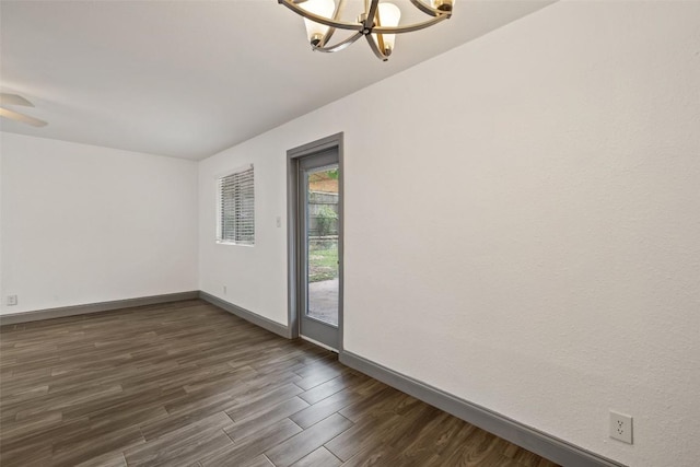 3411 Thomas Kincheon St, Austin, TX 78745 - unfurnished room featuring a chandelier and dark wood-style flooring