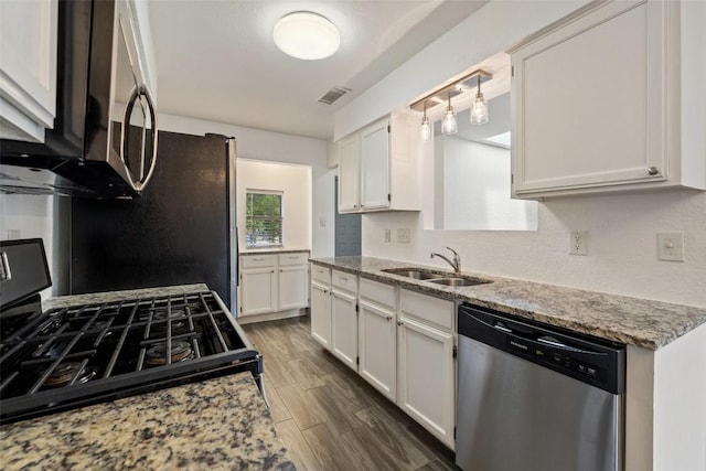 3411 Thomas Kincheon St, Austin, TX 78745 - kitchen featuring stainless steel appliances, white cabinetry, dark wood-style floors, and light stone counters