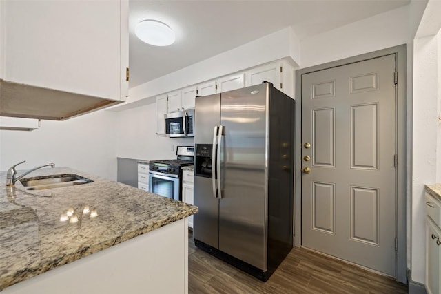 3411 Thomas Kincheon St, Austin, TX 78745 - kitchen with stainless steel appliances, light stone countertops, white cabinets, and dark wood-style floors