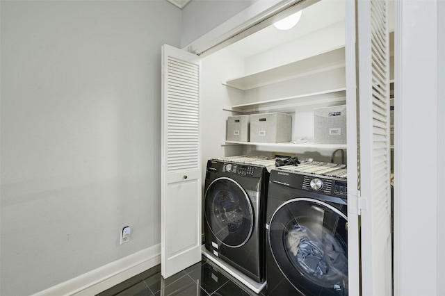 washroom with dark tile patterned flooring and washing machine and clothes dryer