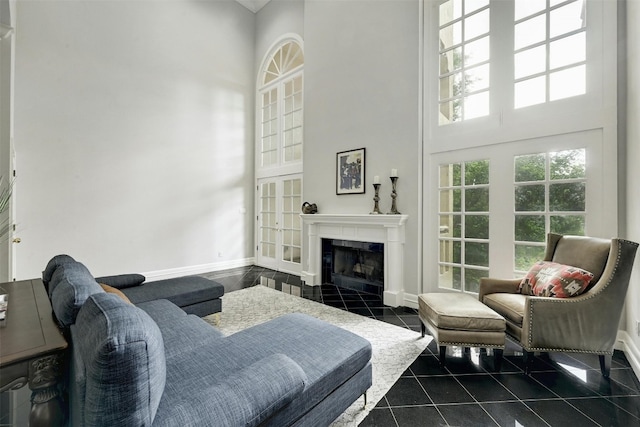 living room featuring a tile fireplace and a high ceiling