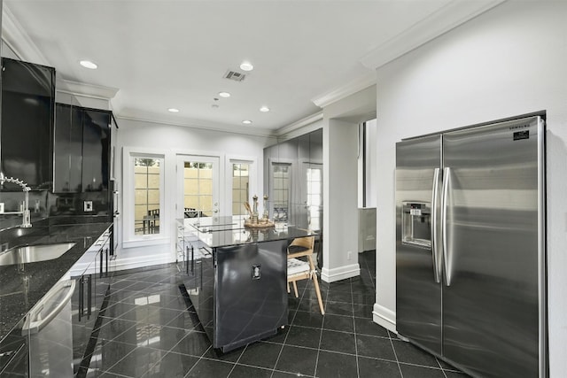 kitchen featuring a breakfast bar area, appliances with stainless steel finishes, sink, and crown molding