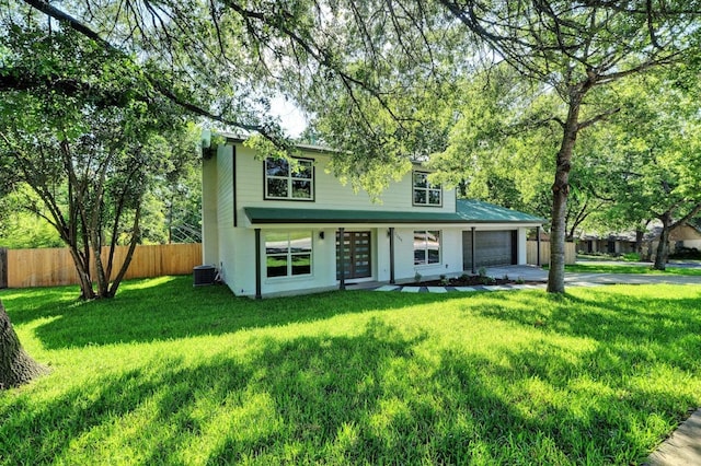 view of front facade featuring a garage, central air condition unit, and a front lawn