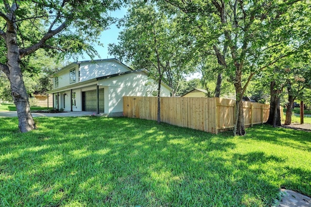 view of yard featuring fence and driveway