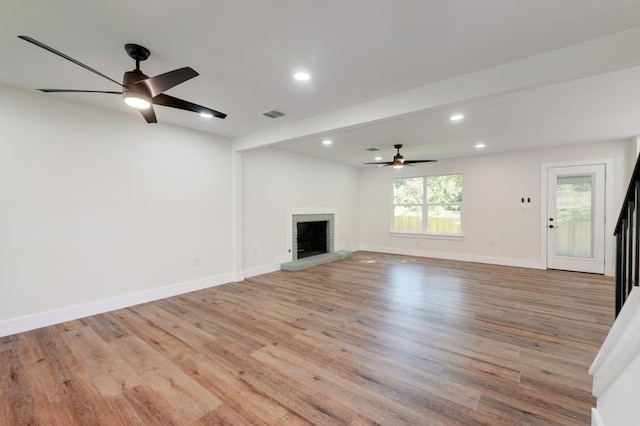 unfurnished living room featuring light hardwood / wood-style flooring, a brick fireplace, and ceiling fan