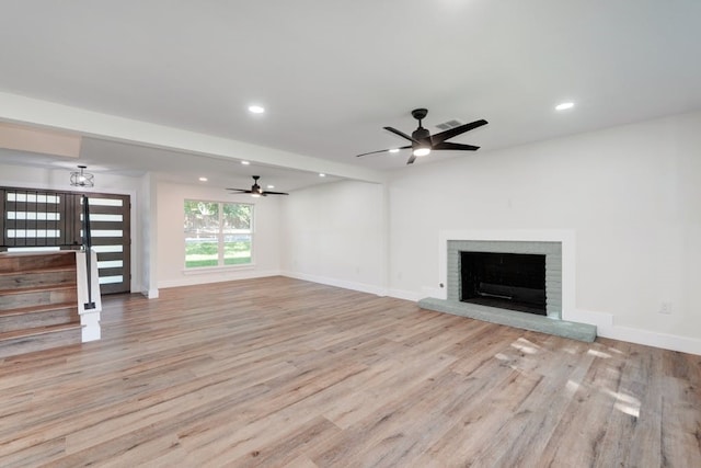 unfurnished living room with a fireplace, light hardwood / wood-style floors, and ceiling fan