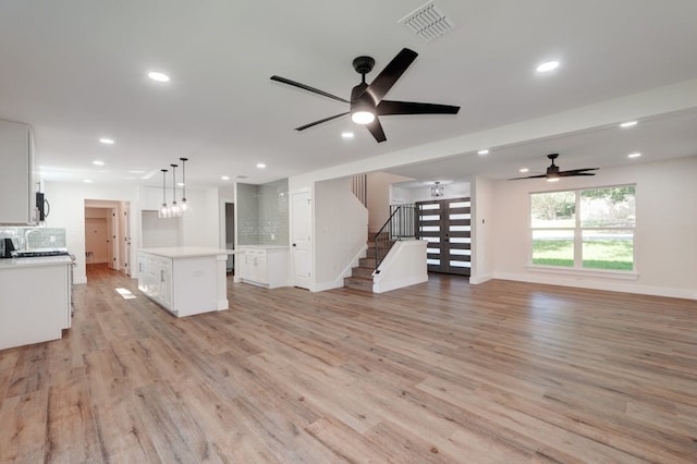 unfurnished living room with light wood-type flooring and ceiling fan