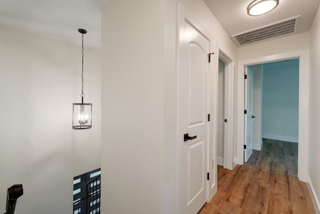 hall featuring hardwood / wood-style floors and a chandelier