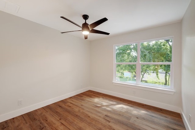 unfurnished room featuring ceiling fan, hardwood / wood-style flooring, and a wealth of natural light