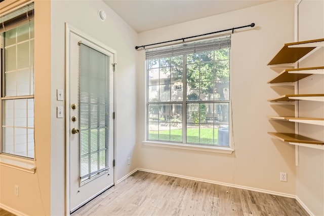 doorway with baseboards and wood finished floors