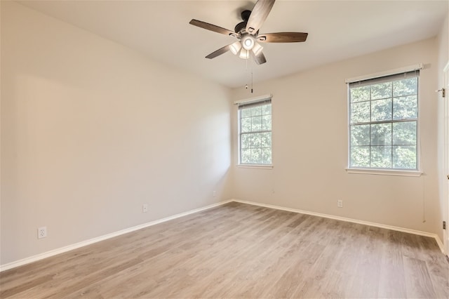 empty room featuring baseboards, a ceiling fan, and light wood finished floors