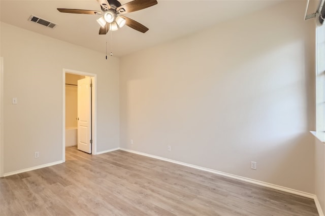 empty room featuring light wood-style floors, baseboards, ceiling fan, and visible vents