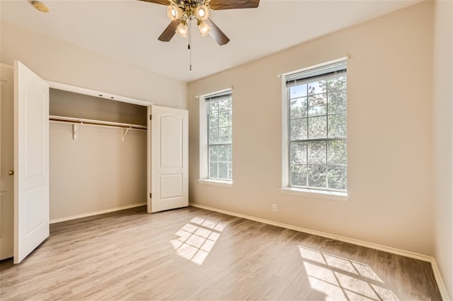unfurnished bedroom with baseboards, light wood-style flooring, ceiling fan, and a closet