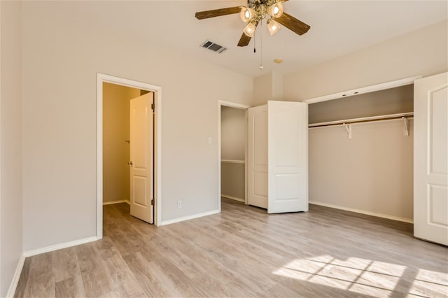 unfurnished bedroom with baseboards, a closet, wood finished floors, and visible vents
