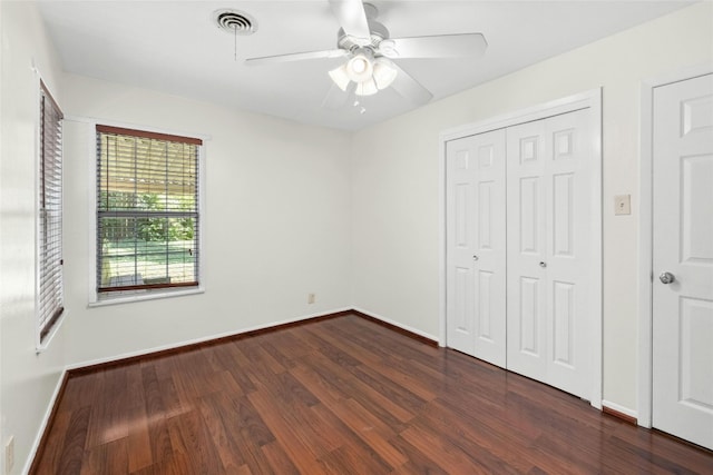 unfurnished bedroom with baseboards, visible vents, a ceiling fan, dark wood-type flooring, and a closet