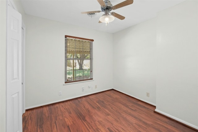 spare room featuring wood finished floors, a ceiling fan, and baseboards