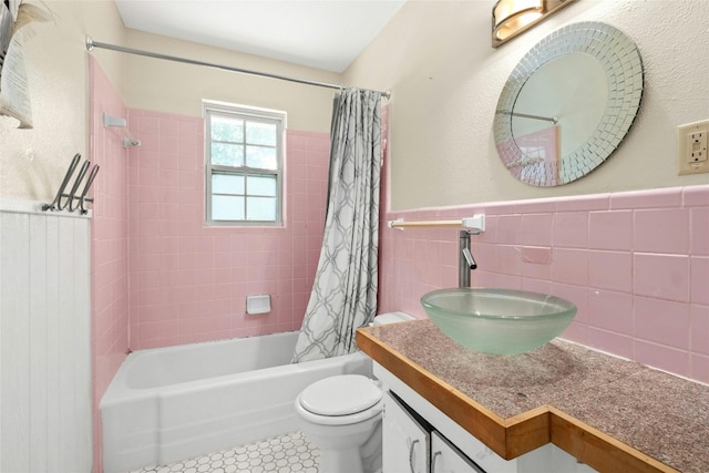 full bathroom featuring tile walls, toilet, shower / tub combo, wainscoting, and tile patterned flooring