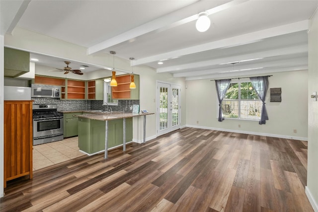 kitchen featuring stainless steel appliances, green cabinets, beam ceiling, decorative backsplash, and open shelves